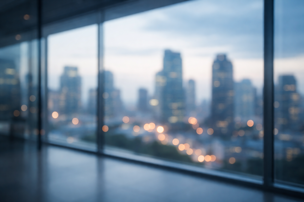 Baggrund til testimonials: uskarp storby- og kontorhorisont set gennem glasfacade – abstrakt og rolig, god til tekst ovenpå.